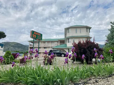 a sign in front of a hotel with purple flowers at Motel 99 in Grand Forks