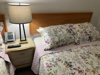 a bedroom with a bed with a lamp and a telephone at Motel 99 in Grand Forks