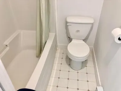 a bathroom with a toilet and a bath tub at Motel 99 in Grand Forks