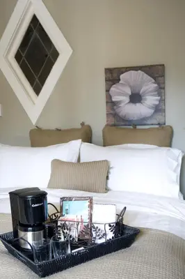a tray with a coffee maker on a bed at The Ivy on Parker Guest House in Vancouver