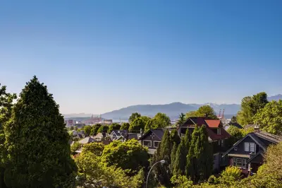 a town with houses and trees and mountains in the background at The Ivy on Parker Guest House in Vancouver