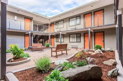 an apartment building with a patio with two benches at Quality Inn Merritt in Merritt
