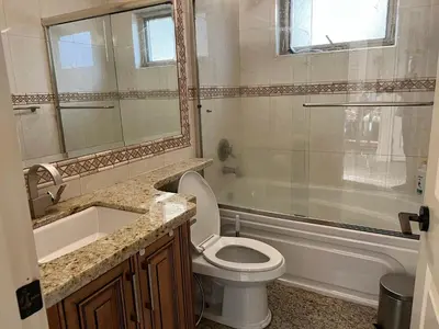 a bathroom with a toilet and a sink and a tub at Mike's Luxury House in Vancouver