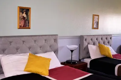a hotel room with two beds with yellow and white pillows at Elite Hotel -Downtown Center- 