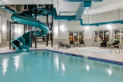 a pool with a water slide in a hotel room at Canalta Brooks in Brooks