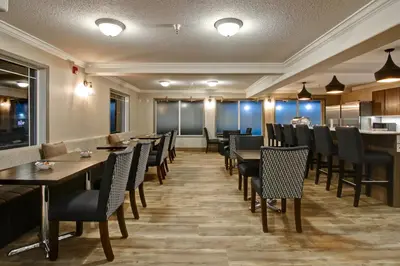 a restaurant with tables and chairs and a kitchen at Canalta Brooks in Brooks