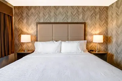a bedroom with a large white bed with two lamps at Canalta Brooks in Brooks