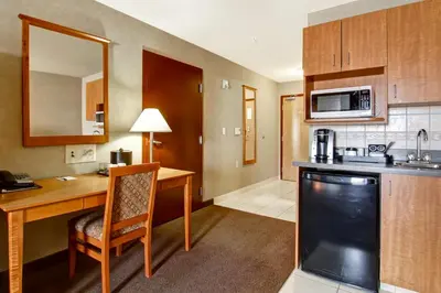a room with a desk and a kitchen with a counter at Canalta Brooks in Brooks