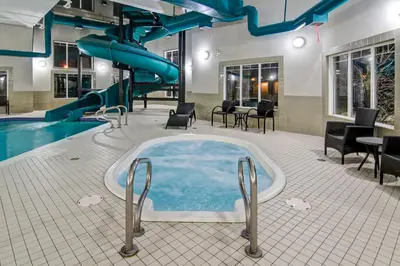 a jacuzzi tub in a pool with a slide at Canalta Brooks in Brooks