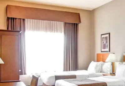 a hotel room with two beds and a window at Canalta Brooks in Brooks