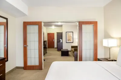a bedroom with a bed and a living room at Ramada by Wyndham Lac La Biche in Lac La Biche