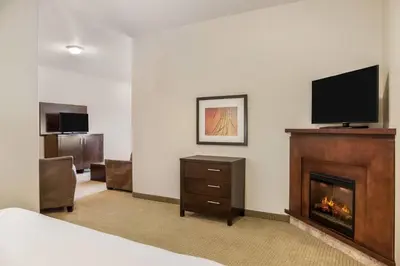 a hotel room with a fireplace and a flat screen tv at Ramada by Wyndham Lac La Biche in Lac La Biche