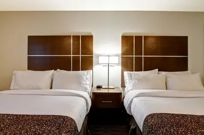 a hotel room with two beds and a table with a lamp at Canalta Hanna in Hanna