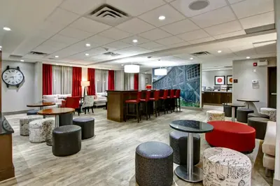 a lobby with tables and stools and a bar at Canalta Hanna in Hanna