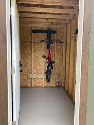 a bike hanging from the wall of a garage at Cougar Mountain Lodge and Resort Cabin Rentals in Valemount