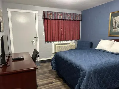a bedroom with a bed and a desk with a computer at Arrow Lake Motel in Fauquier