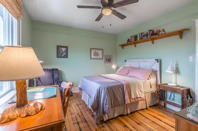 a bedroom with a bed and a table with a lamp at Outdoor Lovers in Port Alberni