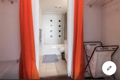 an orange shower curtain in a bathroom with a toilet at Vancouver Downtown Central 1 bedroom Condo in Vancouver