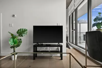 a living room with a flat screen tv on a table at GlobalStay Modern Condos Downtown Calgary in Calgary