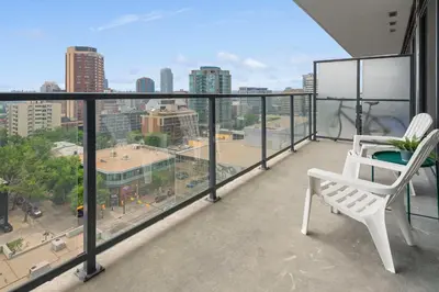 a balcony with two chairs and a view of a city at GlobalStay Modern Condos Downtown Calgary in Calgary
