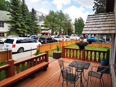 a wooden deck with chairs and a table on it at Riverfront Estate Bed&Breakfast Banff in Banff