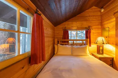 a bedroom with a bed in a log cabin at Storm Mountain Lodge & Cabins in Banff