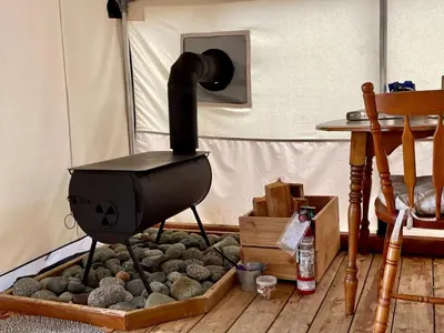 a black stove in a room with rocks at So Damn Lucky Glamping in Ucluelet