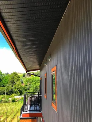 a porch of a house with a black roof at Wesbert Winery & Guest Suites in Penticton
