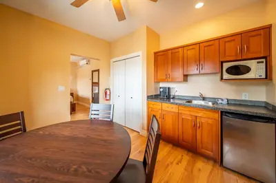 a kitchen with wooden cabinets and a wooden table with a dining room at Halcyon Hot Springs Resort in Halcyon Hot Springs