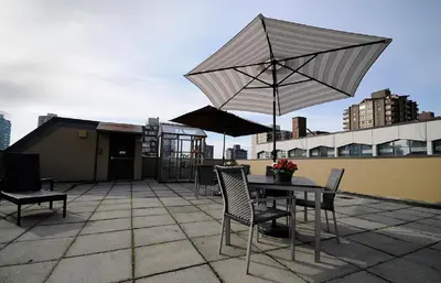 a patio with a table and chairs and an umbrella at HI Vancouver Downtown - Hostel in Vancouver
