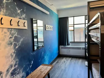 a room with a blue wall and bunk beds at HI Vancouver Downtown - Hostel in Vancouver