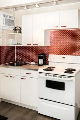 a white kitchen with a stove and a sink at Crescent Motel in Radium Hot Springs