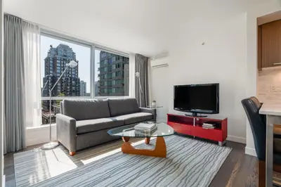 a living room with a couch and a flat screen tv at Level Vancouver Yaletown - Seymour in Vancouver