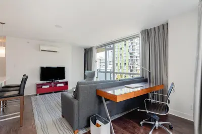 a living room with a couch and a desk and a tv at Level Vancouver Yaletown - Seymour in Vancouver