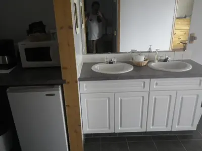 a man taking a picture of a bathroom with two sinks at Alcan Motor Inn in Haines Junction