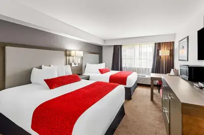 a hotel room with two beds and a television at Best Western Cowichan Valley Inn in Duncan