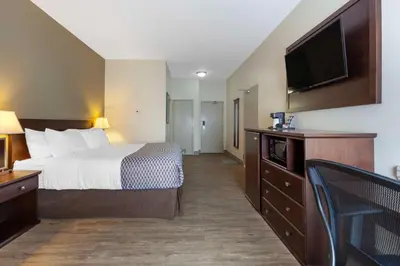 a hotel room with a bed and a flat screen tv at Best Western High Road Inn in Edson