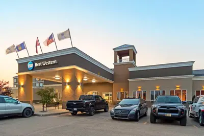 a dealership with cars parked in a parking lot at Best Western High Road Inn in Edson