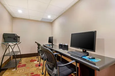 a room with a desk with a computer and chairs at Best Western Northgate in Nanaimo