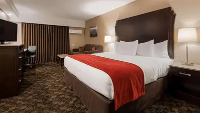 a hotel room with a large bed with a red blanket at Best Western Northgate in Nanaimo