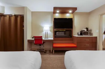 a hotel room with two beds and a desk with a tv at Best Western PLUS City Centre Inn in Edmonton