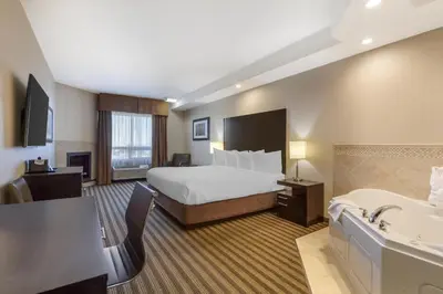 a hotel room with a bed and a bath tub at Best Western Plus Sherwood Park in Sherwood Park
