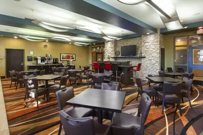 a restaurant with tables and chairs and a bar at Best Western Plus Sherwood Park in Sherwood Park