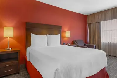 a large bed in a hotel room with red walls at Best Western Terrace Inn in Terrace