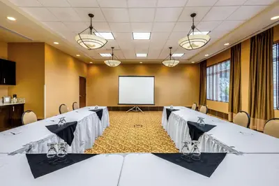 a conference room with tables and a projector screen at Best Western Sunrise Inn & Suites in Stony Plain