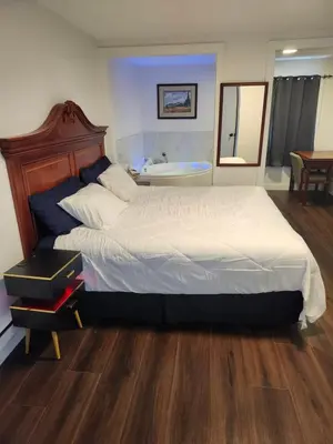 a bedroom with a large bed and a bath tub at Cache Creek Inn in Cache Creek