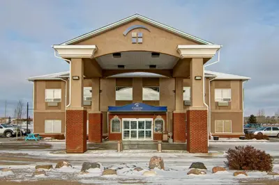 a large building with snow in front of it at Canalta Oyen in Oyen