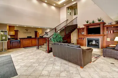 a large living room with a staircase and a fireplace at Canalta Oyen in Oyen