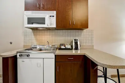 a small kitchen with a sink and a microwave at Canalta Oyen in Oyen