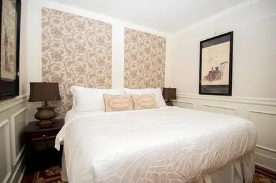 a bedroom with a bed with a white comforter at The Craigmyle Inn in Victoria